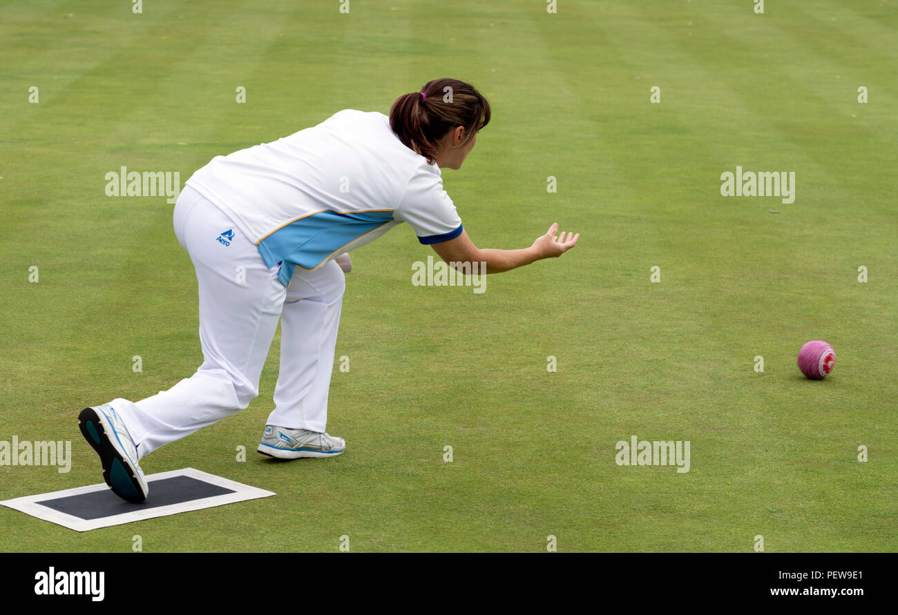 A player bowling a wood at the national women`s lawn bowls